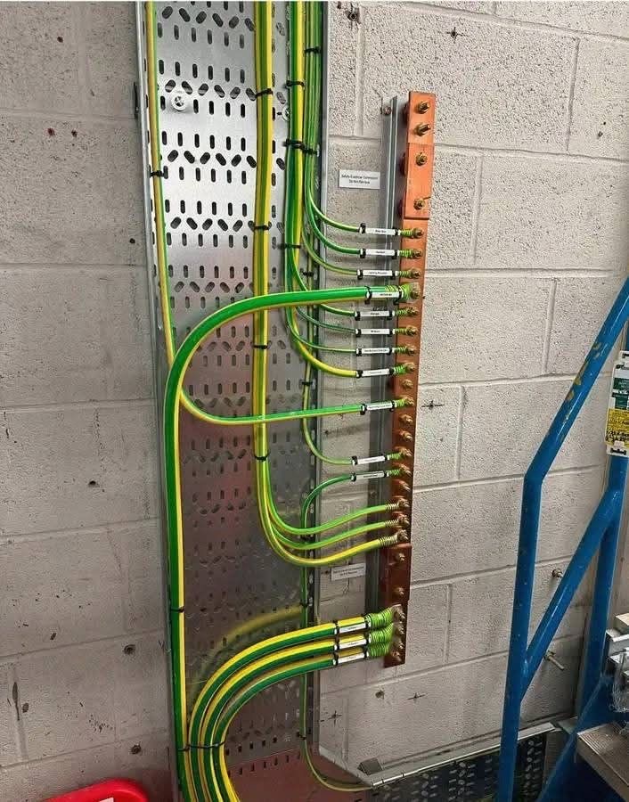 Services Copper earth busbar with labelled protective earth conductors installed for an industrial electrical system by Sha Technical Solutions Ltd.